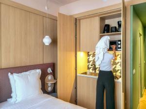 a person is looking into a cupboard in a bedroom at Aparthotel AMMI Nice Lafayette - Reopening 2023 in Nice