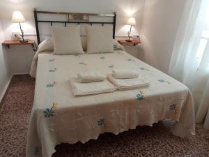 1 dormitorio con 1 cama con toallas en Casa Pinos en Siles