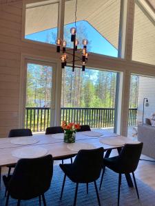 una sala da pranzo con un grande tavolo e sedie di Villa Iiris - New Holiday Home ad Äkäslompolo