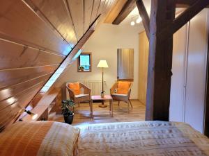 a bedroom with a bed and a staircase with chairs at Ferienwohnungen Stephan in Marienberg