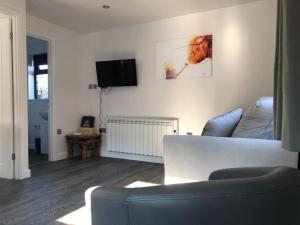 a living room with a couch and a tv at Ash Cottage in Skegness