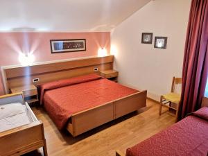 een slaapkamer met een bed met een rood dekbed bij Residence Capriolo in Lavarone