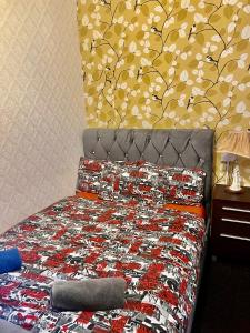 een slaapkamer met een bed met een muurschildering van bomen aan de muur bij Blackpool Central Hotel in Blackpool