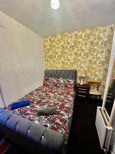 een slaapkamer met een bed en een muur met een sprei bij Blackpool Central Hotel in Blackpool