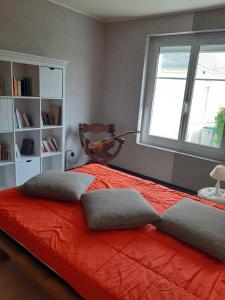 a bedroom with a bed with two pillows and a window at Maison bord de mer Penmarch in Penmarcʼh