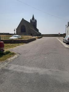 an empty road in front of a large church at Maison bord de mer Penmarch in Penmarcʼh +2 photos