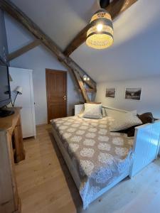 a bedroom with a bed and a ceiling with beams at La maison des commis in Morestel