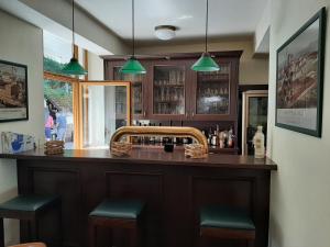 um bar com bancos verdes num quarto em Waldhotel Pfarrmühle em Eisenberg