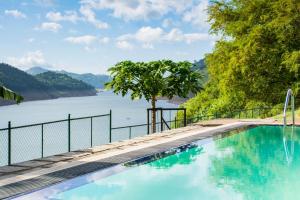 een zwembad met uitzicht op een meer bij Villa Victoria Edge in Digana