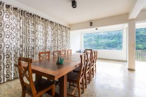 comedor con mesa de madera y sillas en Villa Victoria Edge en Digana