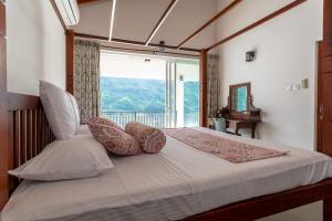 a bedroom with a bed with a large window at Villa Victoria Edge in Digana +33 photos
