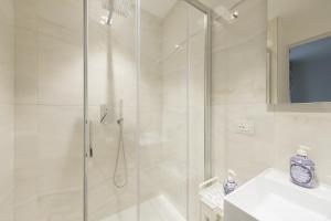 a white bathroom with a shower and a sink at Supernova in Savona