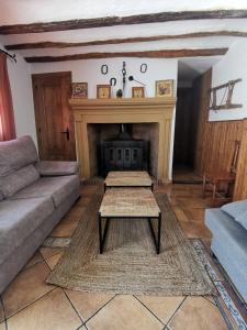 sala de estar con sofá y chimenea en Casa Rural El Gandulillo en Castril