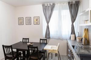 een eetkamer met een zwarte tafel en stoelen bij Apartman Pletisanak in Gornji Milanovac