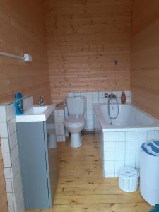 uma casa de banho com um WC, uma banheira e um lavatório. em Domki letniskowe nad morzem em Pogorzelica