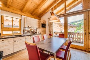 a kitchen with a dining room table and chairs at Chalet am Teich in Neukirchen am Großvenediger