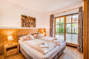 a bedroom with a large bed and a window at Chalet am Teich in Neukirchen am Großvenediger