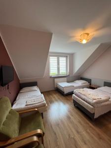 a attic room with two beds and a couch at Garden Villa in Busko-Zdrój