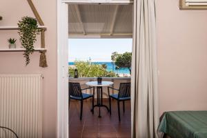 a room with a balcony with a table and chairs at Diamond Palace in Gythio