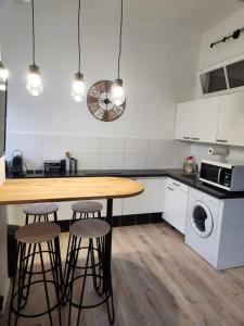 een keuken met een houten tafel en drie barkrukken bij Superbe studio au cœur de Nice ! in Nice