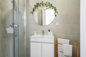 a bathroom with a sink and a mirror at Comfy Sunny Flat - Prime Location in Porto