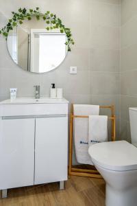a bathroom with a white toilet and a mirror at Host Wise - Comfy Sunny Flat - Prime Location in Porto