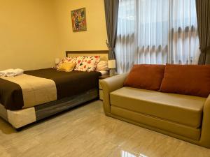 a bedroom with a bed and a couch at Casa Familia Syariah in Sleman