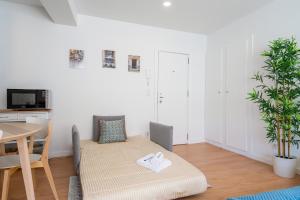 uma pequena sala de estar com uma mesa e uma mesa em Comfy Sunny Flat - Prime Location em Porto