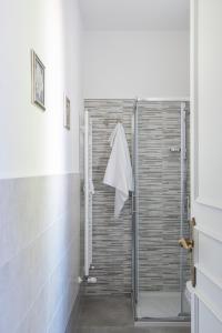 La salle de bains est pourvue d'une douche avec une porte en verre. dans l'établissement Hotel Posta, à Orvieto