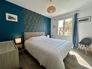 Schlafzimmer mit einem Bett mit blauen Wänden und einem Fenster in der Unterkunft Maison Saint-Pierre-d'Oléron, 4 pièces, 6 personnes - FR-1-246A-195 in Saint-Pierre-dʼOléron
