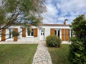 ein weißes Haus mit braunen Türen und einem Hof in der Unterkunft Maison Saint-Pierre-d'Oléron, 4 pièces, 6 personnes - FR-1-246A-195 in Saint-Pierre-dʼOléron