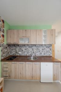 a kitchen with wooden cabinets and a white refrigerator at City Code Spa in Belgrade