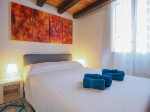 a bedroom with a bed with two blue pillows on it at Casa Maretta in Cagliari