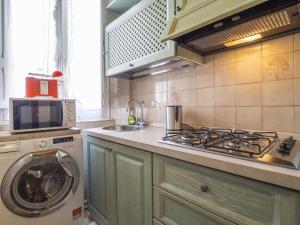 a kitchen with a stove and a washing machine at Casa Maretta in Cagliari