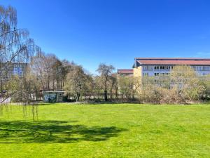 a large grass field with a building in the background at Nice Apartment In Rdovre Close To The Highway in Rødovre