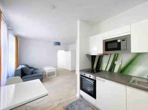 uma cozinha com armários brancos e uma sala de estar em City Centre Praha 1 505 em Praga