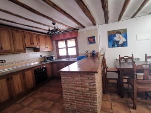 カストリルにあるCasa Rural El Gandulilloのキッチン(木製のキャビネット、テーブル付)