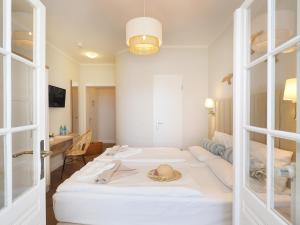 ein Zimmer mit einem Bett mit Hut darauf in der Unterkunft Strandvillen Heringsdorf in Heringsdorf