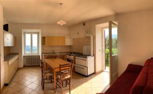 a kitchen with a table and chairs and a couch at Agritur Maso Forcola in Brez