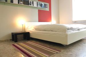 1 dormitorio con cama blanca y mesa auxiliar en Nest - Baarerstrasse 45, en Zug