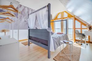 ein Schlafzimmer mit einem Himmelbett in der Unterkunft Pebble Paradise Beachfront Family Getaway in Pevensey