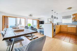 a kitchen and living room with a table and chairs at Pebble Paradise Beachfront Family Getaway in Pevensey