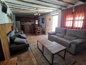 sala de estar con sofá y mesa en Casa Rural El Gandulillo, en Castril