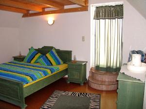 a bedroom with a green bed and a window at Ferienwohnung Seeleshof in Geisa