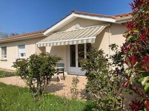 una casa con portico e un tavolo di fronte di Belle maison sur la Voie Verte, Mâcon-Cluny, 6 personnes a Charnay-lès-Mâcon