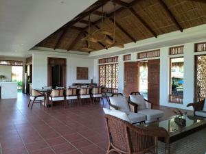 a lobby with chairs and tables and windows at Costa Celine Beach Resort in Kinablañgan