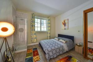Schlafzimmer mit einem Bett und einer Glasdusche in der Unterkunft L'Alhambra - Gîte Haut de Gamme in Vierzon
