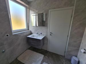 a bathroom with a sink and a window and a mirror at Apartments Elizabeta in Dramalj +36 photos