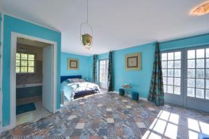 - une chambre avec des murs bleus et un lit dans l'établissement L'Alhambra - Gîte Haut de Gamme, à Vierzon