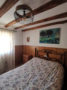 sypialnia z łóżkiem i żyrandolem w obiekcie Casa Rural El Gandulillo w mieście Castril
